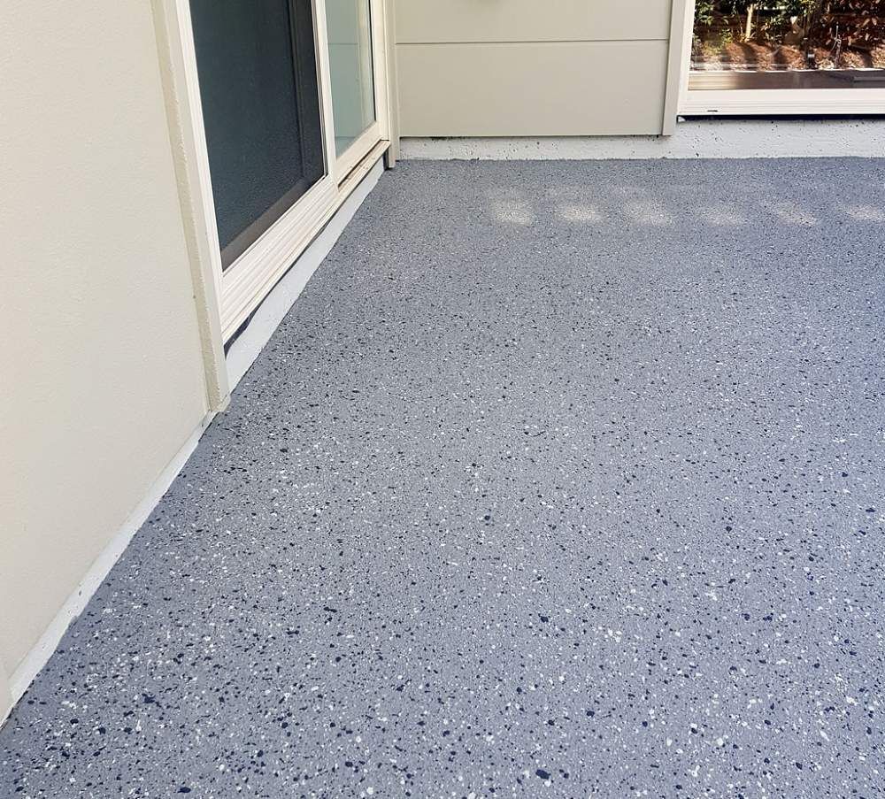 A Gray Concrete Floor With a Sliding Glass Door in the Background — Mid North Coast Spray Pave in Port Macquarie, NSW