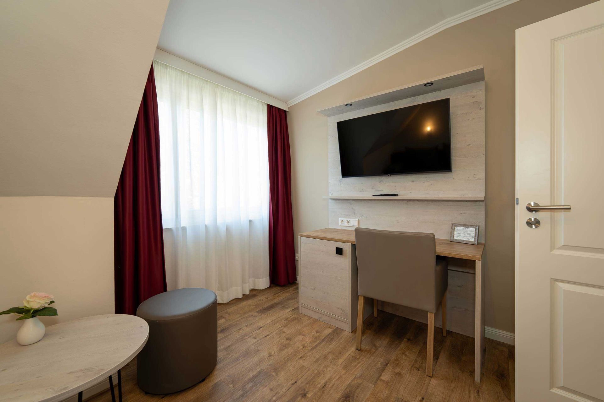 Praktischer Schreibtisch und 43-Zoll 4k-SmartTV im Wohnzimmer des kleinen Apartment des Boutique Hotel Rosengarten Hamburg.