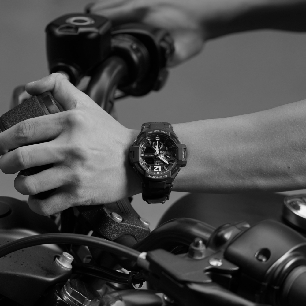 Silver and black dive watch with black leather band, white dial markers, and date window.