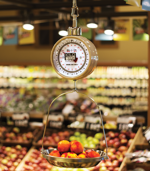 Balance suspendue vintage dans une épicerie, pesant des pêches.
