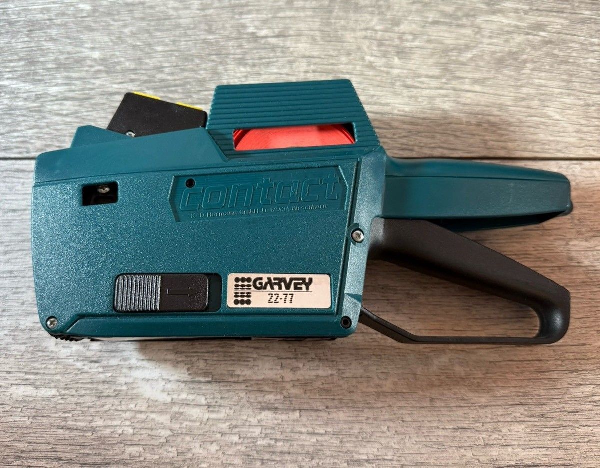 Étiqueteuse de prix Garvey turquoise sur une surface en bois.