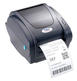 Imprimante d'étiquettes gris foncé imprimant une étiquette avec texte et code-barres.