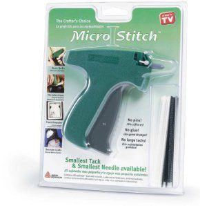 Outil de couture portatif Micro Stitch vert avec bâtonnets de fixation noirs et blancs dans son emballage.