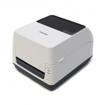 Imprimante d'étiquettes Toshiba blanche. Dessus noir, fente de sortie. Boutons de commande en façade.