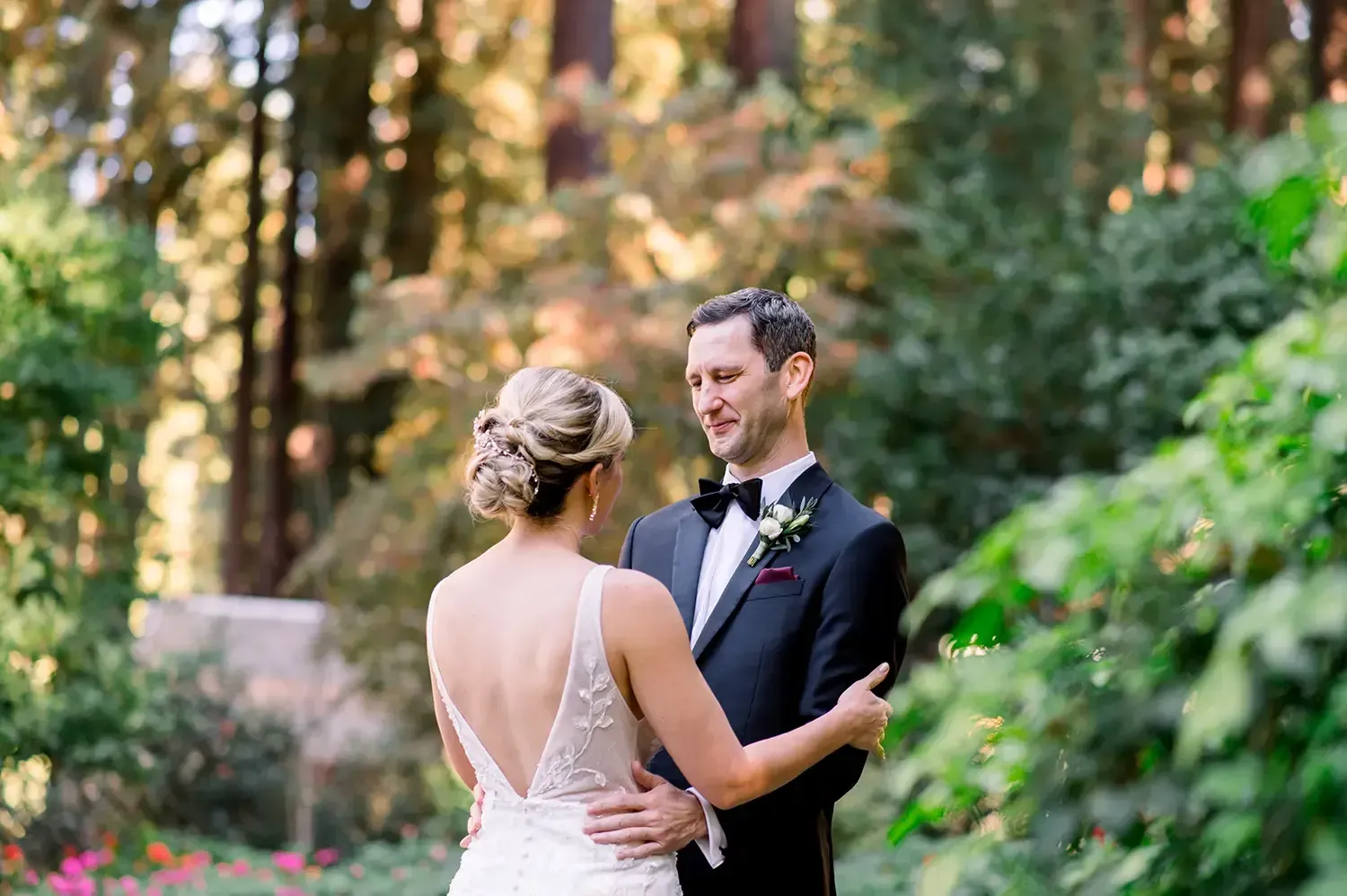 Bride wearing a romantic low bun dancing with groom in romantic setting