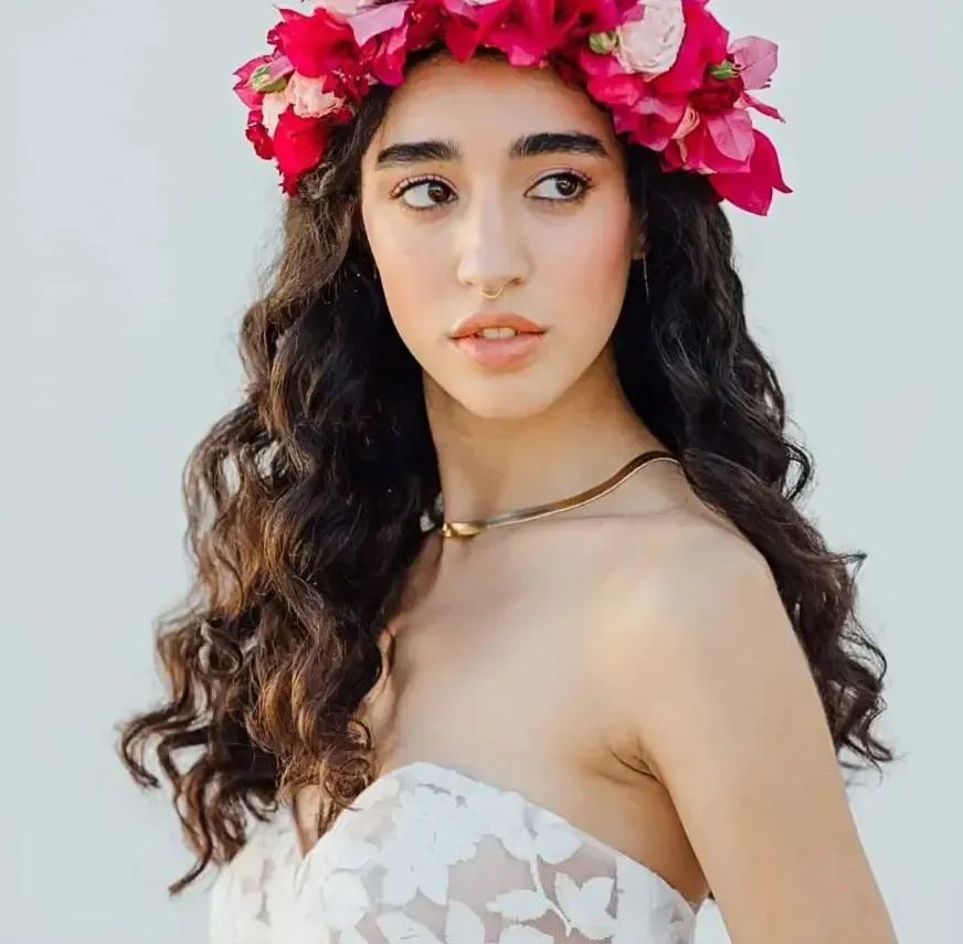Bridal hairstyle with loose curls, colorful flower crown and natural makeup
