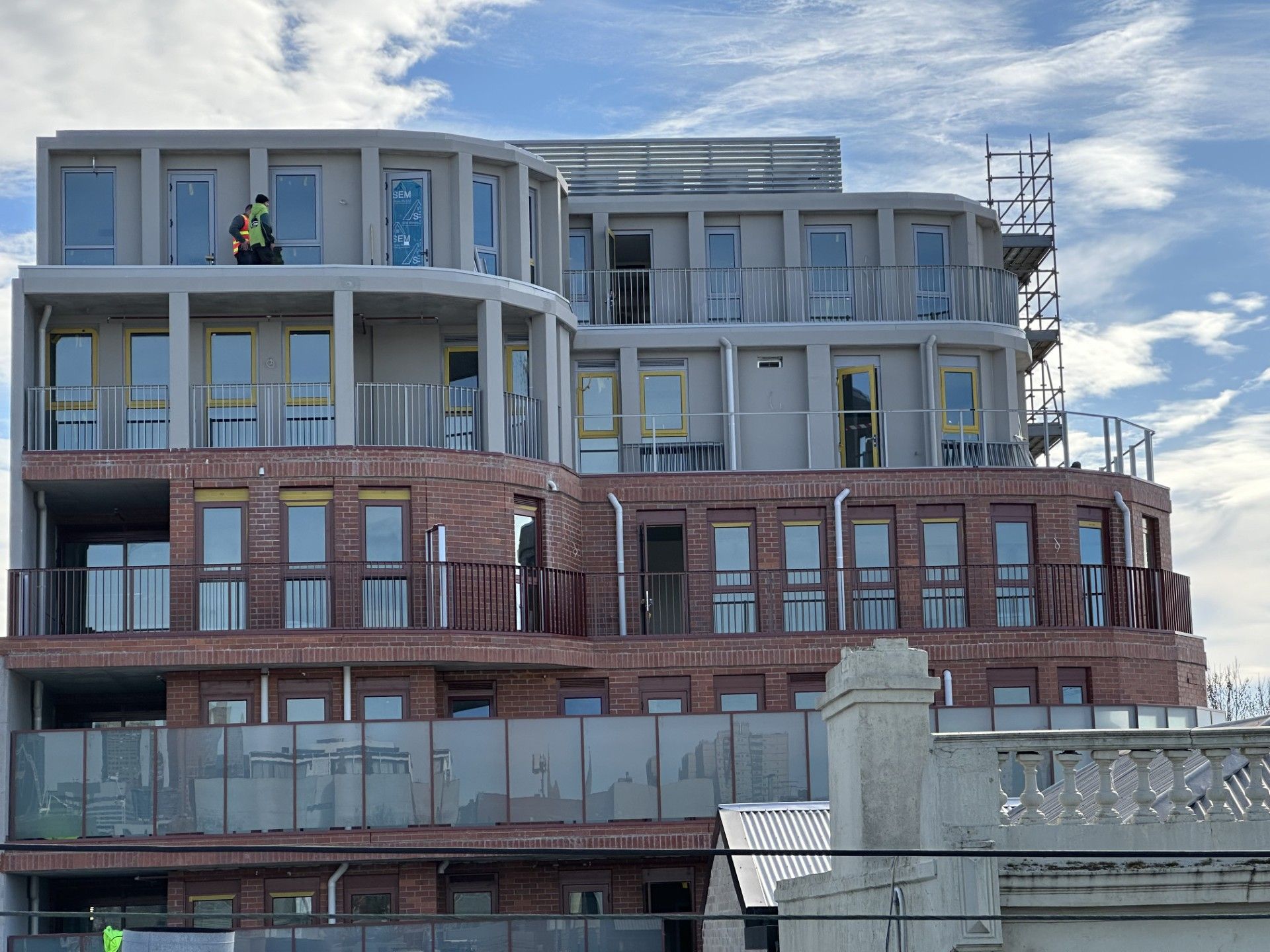 A large building under construction with a lot of windows and balconies.