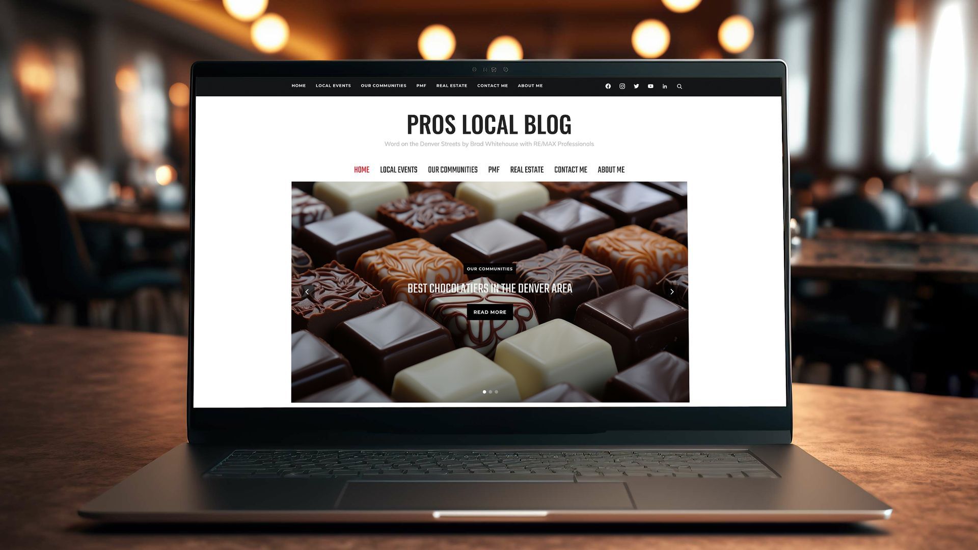 Laptop on wooden table displaying a chocolate truffle website in a café setting