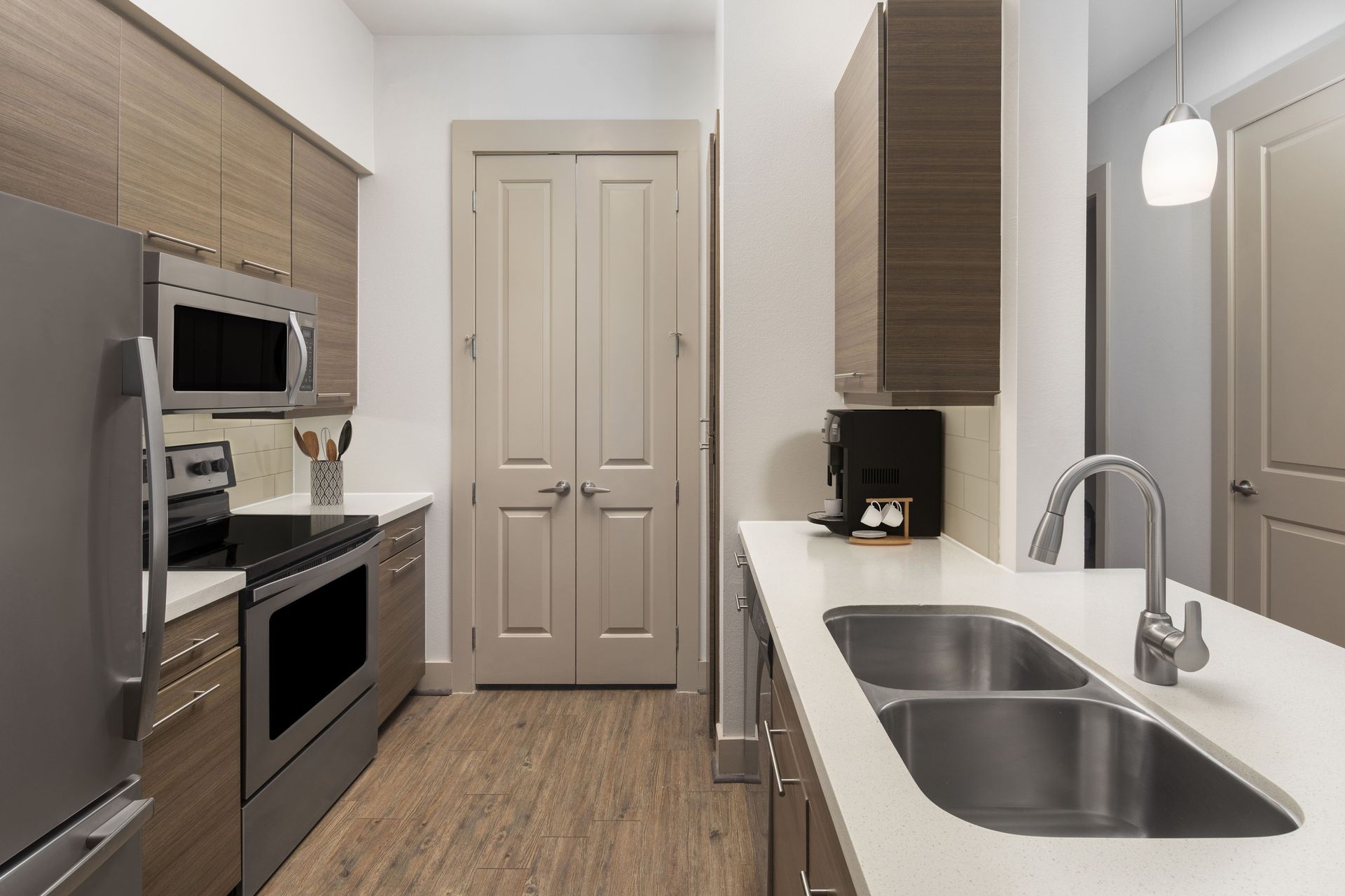Modern kitchen with stainless steel appliances and wooden cabinetry at Marquis Enclave, offers apartments for rent in Midtown Houston, TX.