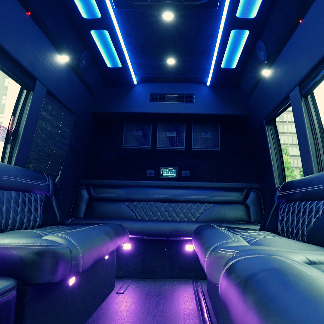 Luxury limousine interior with blue LED ceiling lights and black leather seats