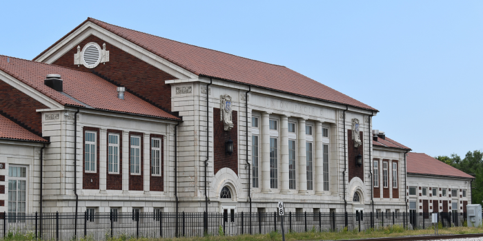 A large, ornate building with white walls, red roof, and several windows.
