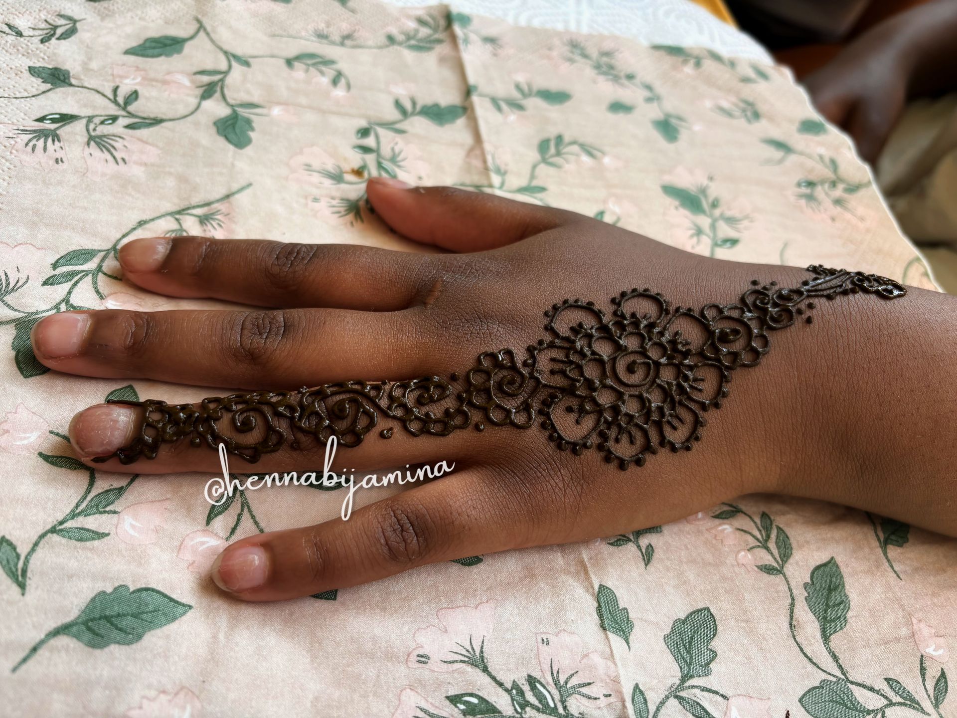 Henna-handontwerp: ingewikkeld donkerbruin bloemenpatroon op donkere huid.