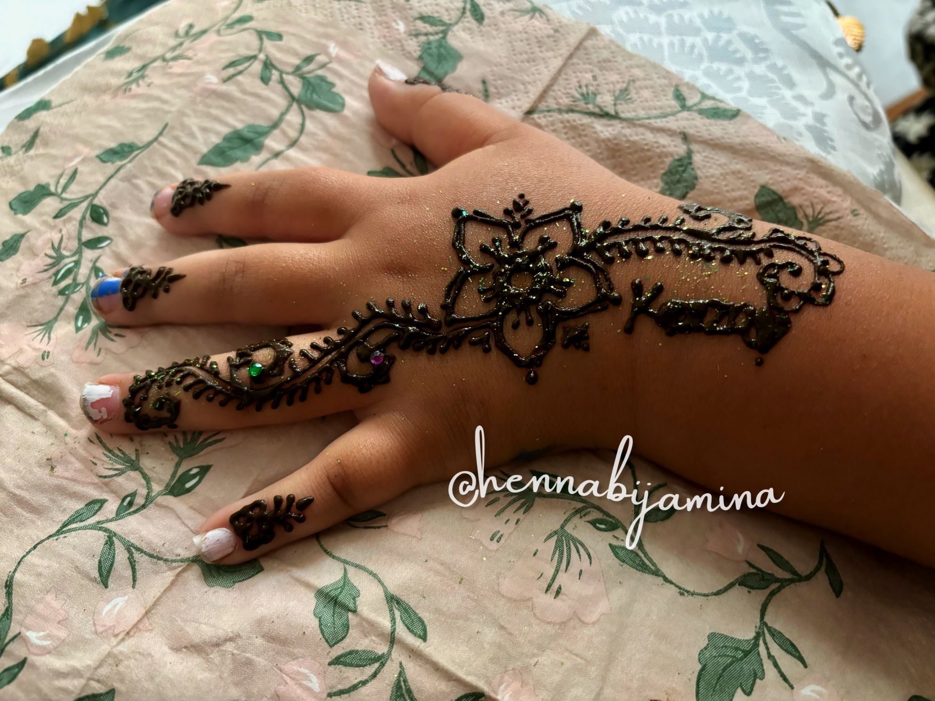 Hand met ingewikkeld henna-ontwerp in zwart.