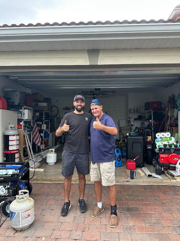 Uplift technician and a customer standing beside an open garage door