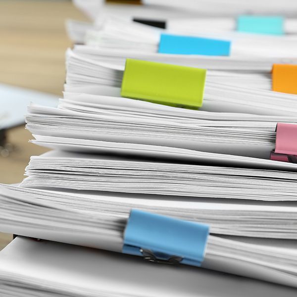 Stack of white papers with colorful sticky tabs clipped on the edges