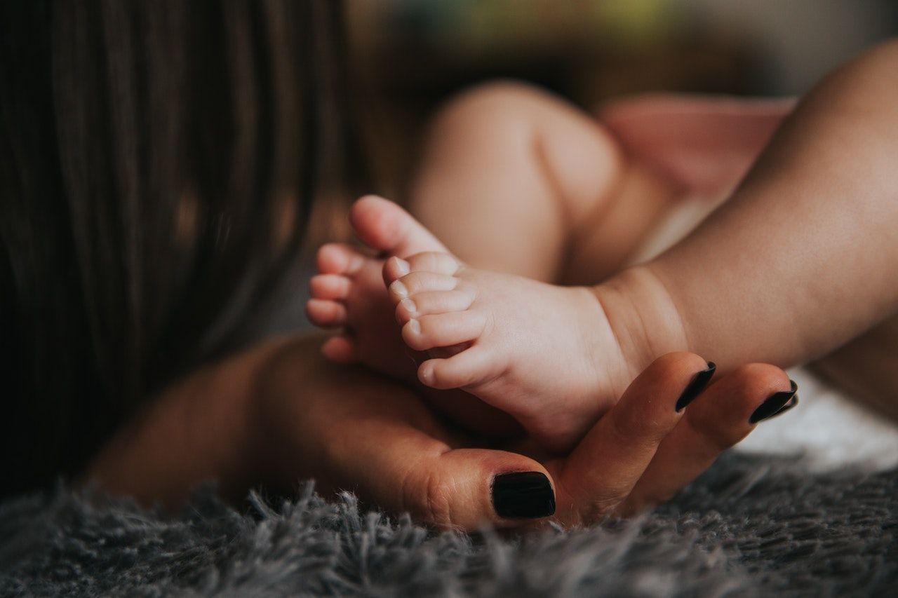 woman hand holding an infant's feet