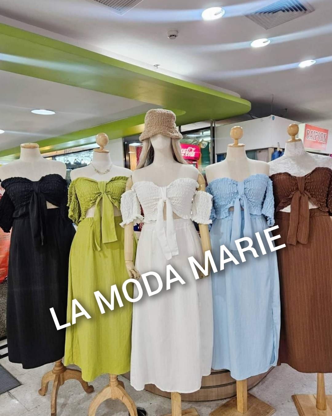 A bunch of dresses are on mannequins in a store.
