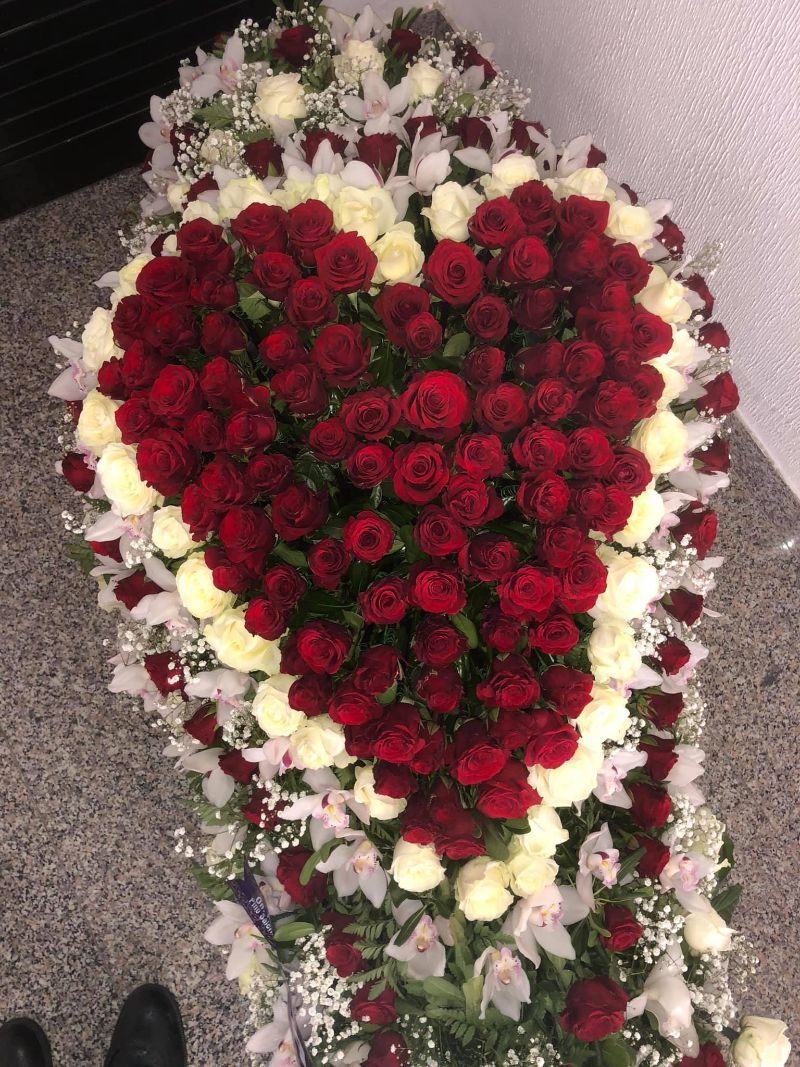 Composizione floreale composta da rose rosse e bianche a forma di cuore.