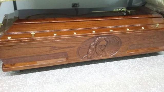 Cofanetto in legno con immagine intagliata e croci dorate.