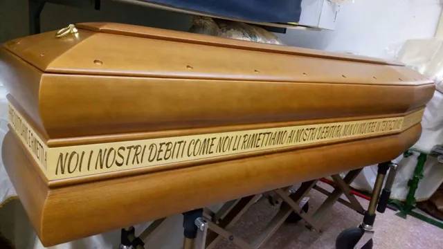 Bara di legno marrone con scritte dorate sul lato, esposta su un supporto.