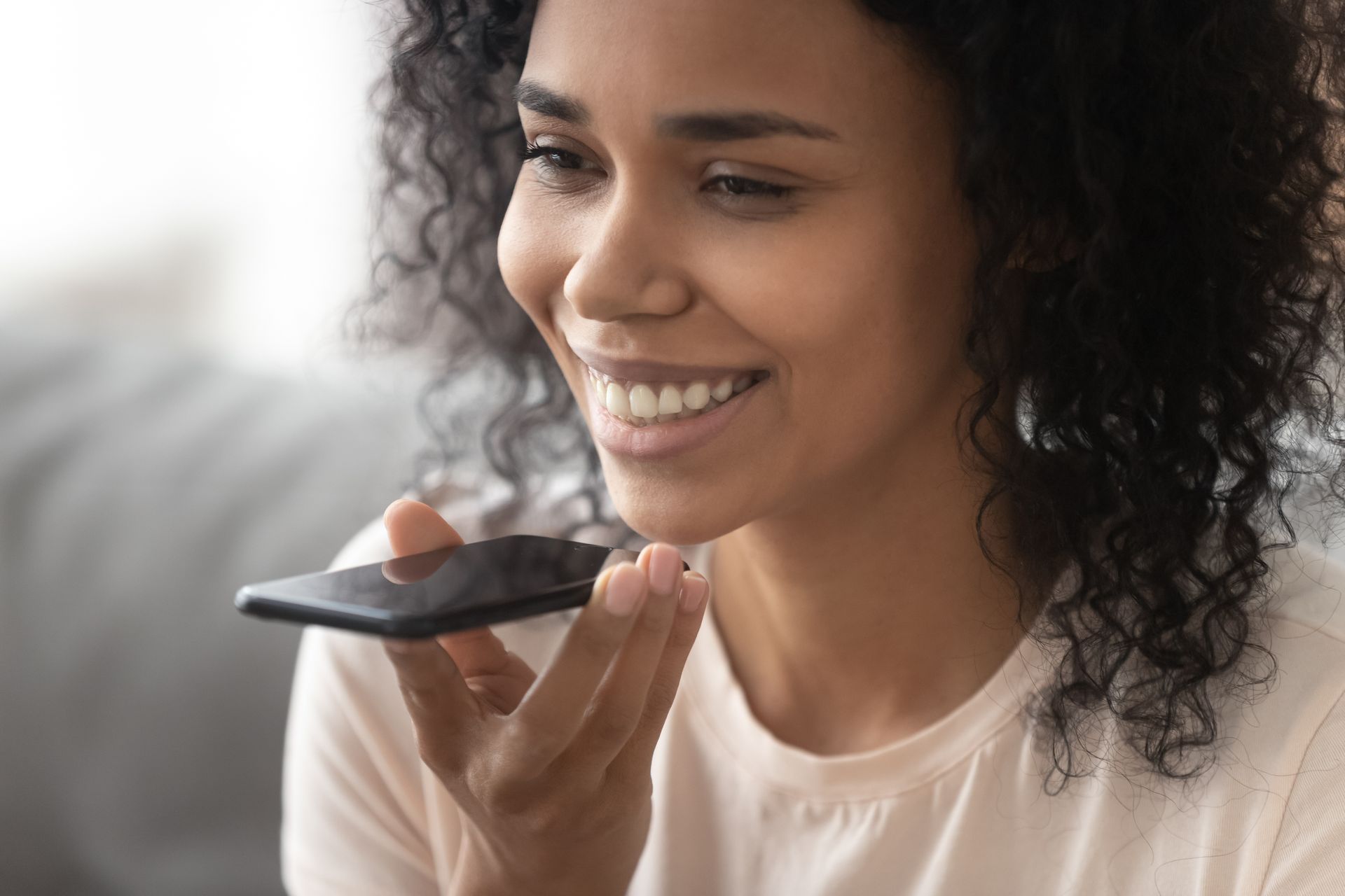 A person using a smartphone to perform a voice search, demonstrating the importance of voice search