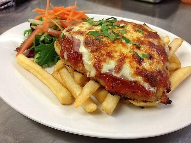 A Person is Holding a White Plate With a Piece of Food on It — Cafe Nosh in Taree, NSW