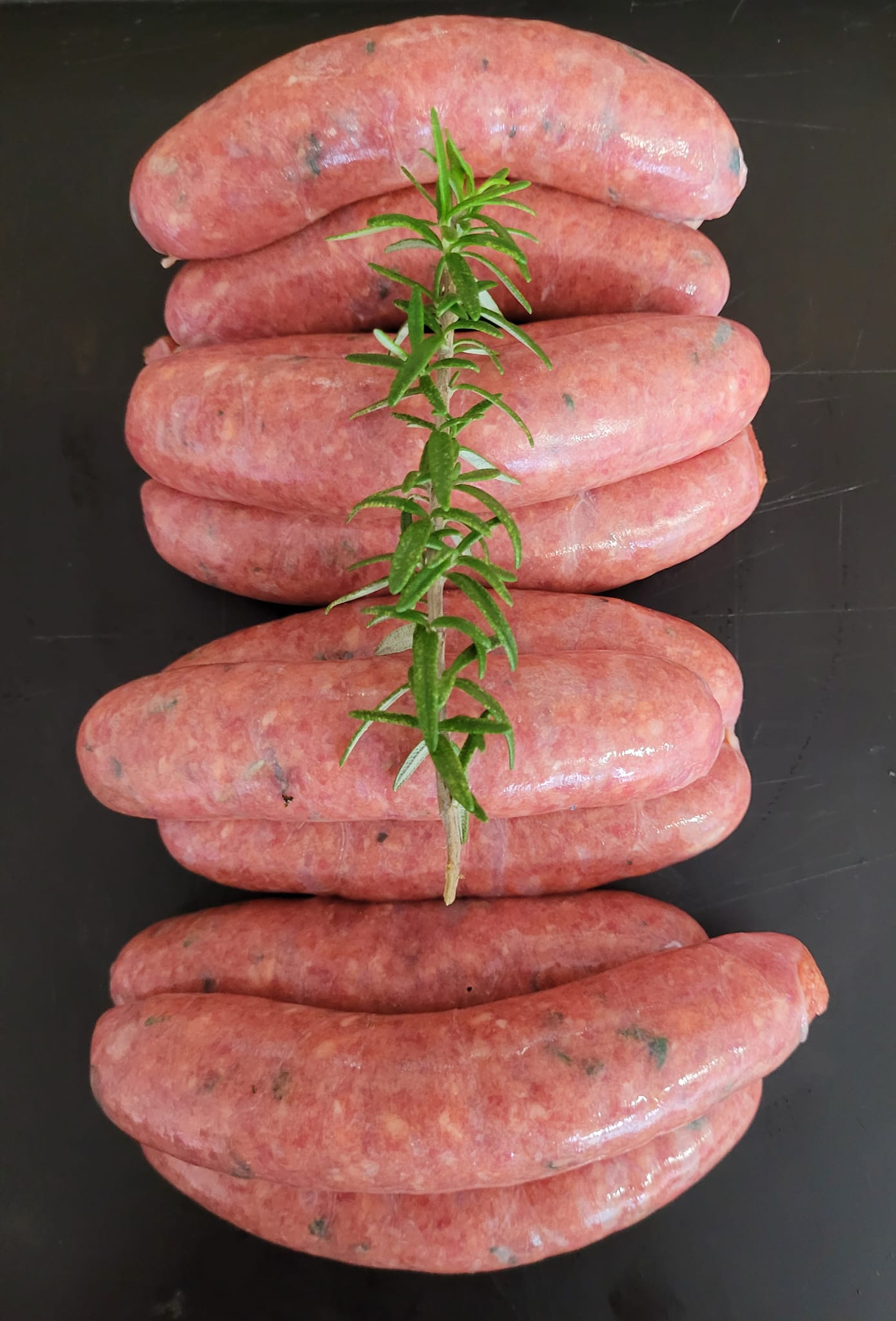 Raw Sausages Arranged with a Sprig of Rosemary — Drovers Meats in Coffs Harbour, NSW
