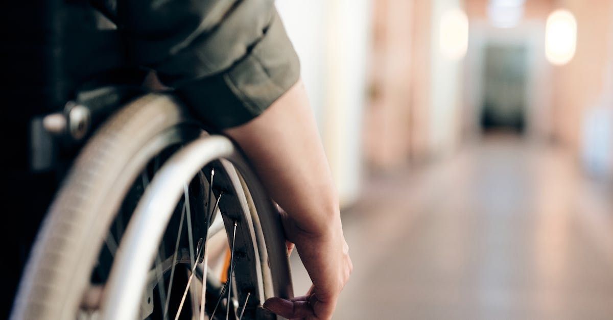A person in a wheelchair is standing in a hallway.