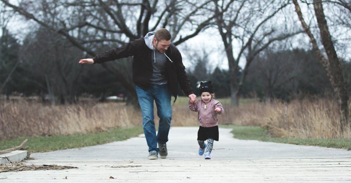 A man and a little girl are walking down a path.