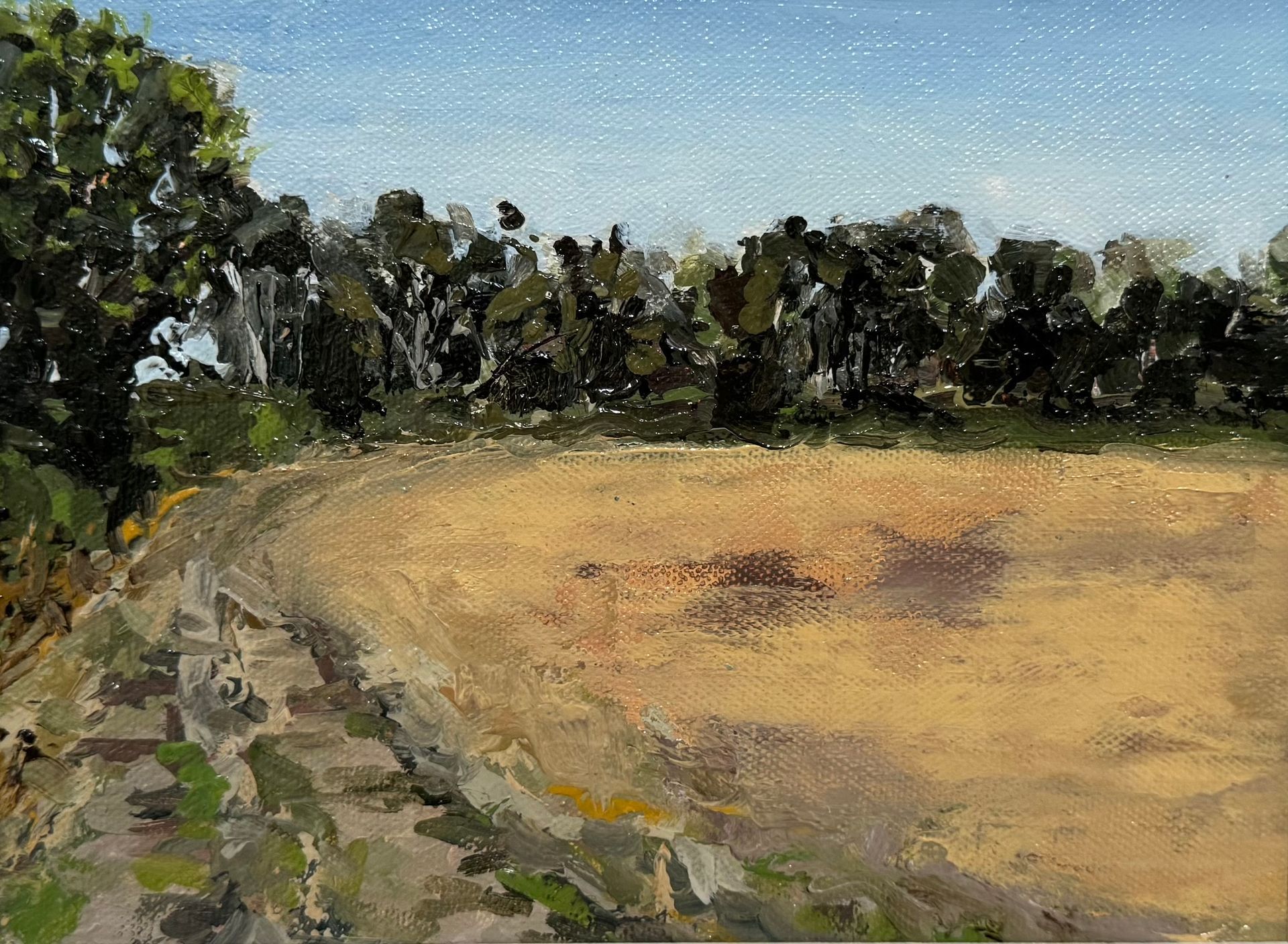 Impressionist landscape of a dry field bordered by trees under a blue sky