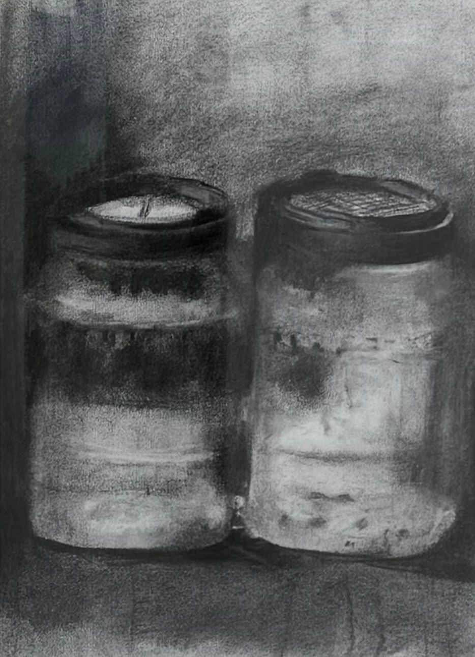 Two black-and-white jars or cans side by side on a textured gray background