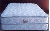 A white mattress is sitting on top of a wooden table.
