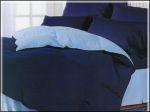 A bed with a blue comforter and pillows on it.
