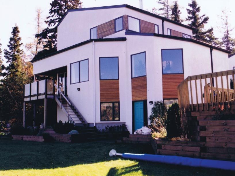 Une grande maison blanche avec une porte bleue et des escaliers