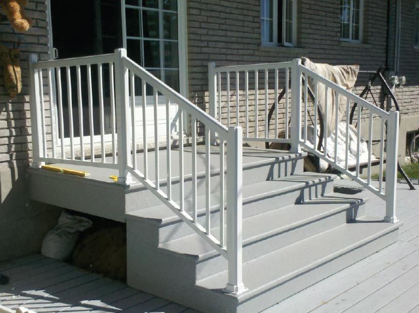 Une terrasse avec des escaliers et une balustrade blanche