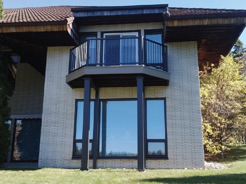Une maison avec un balcon et beaucoup de fenêtres
