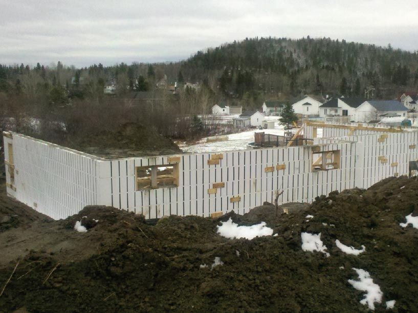 Un gros tas de terre se trouve devant un bâtiment en construction
