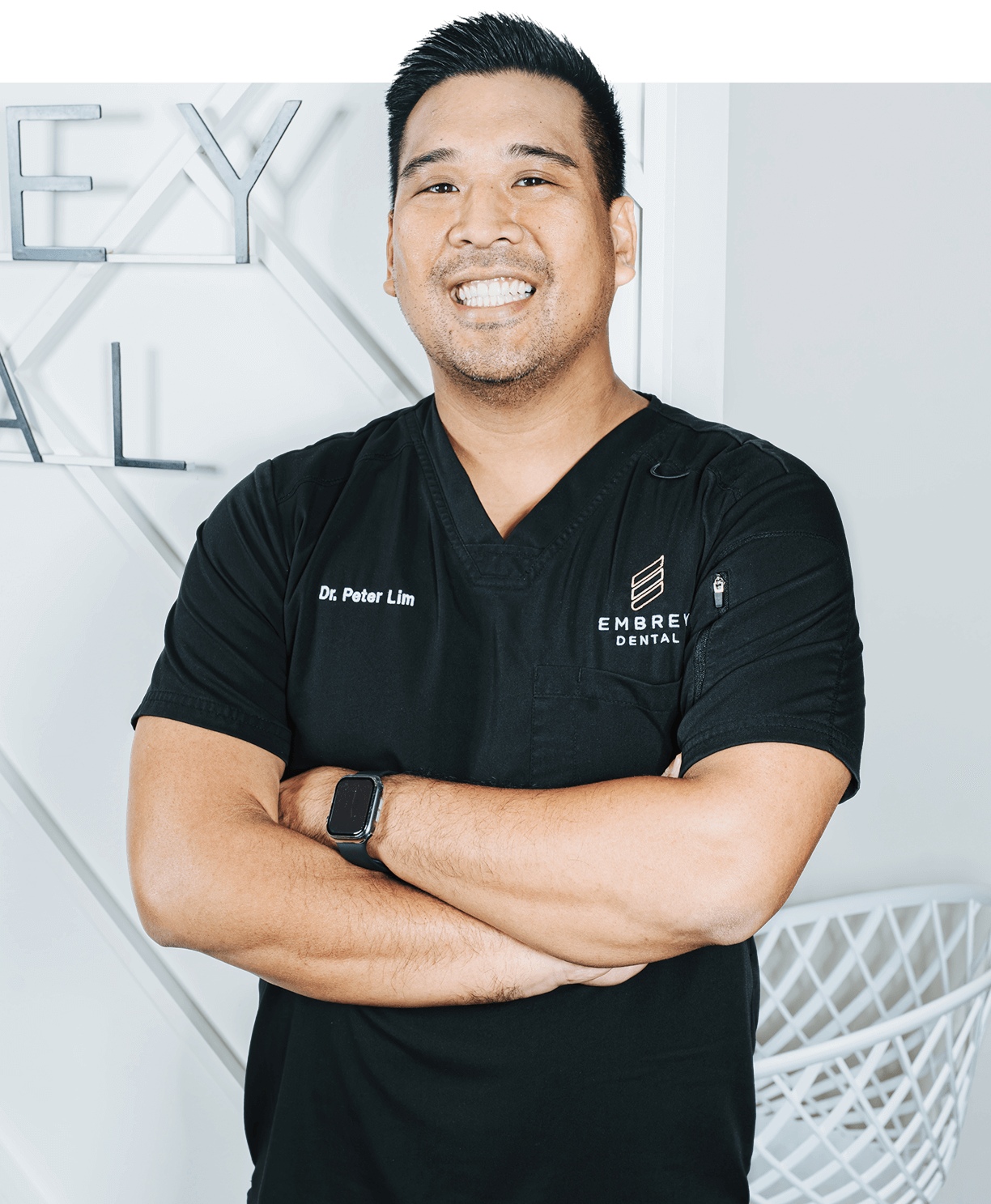 dr. lim standing in embrey dental office smiling and happy with kids running in the background at Family dentistry