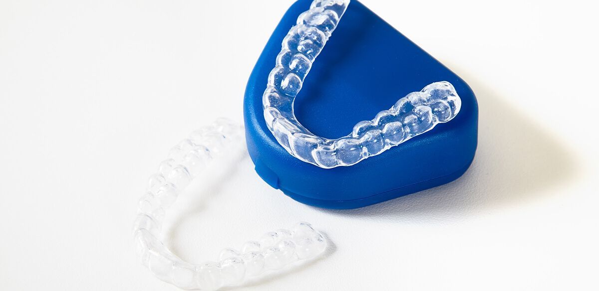 Blue and clear plastic dental aligner on a white background