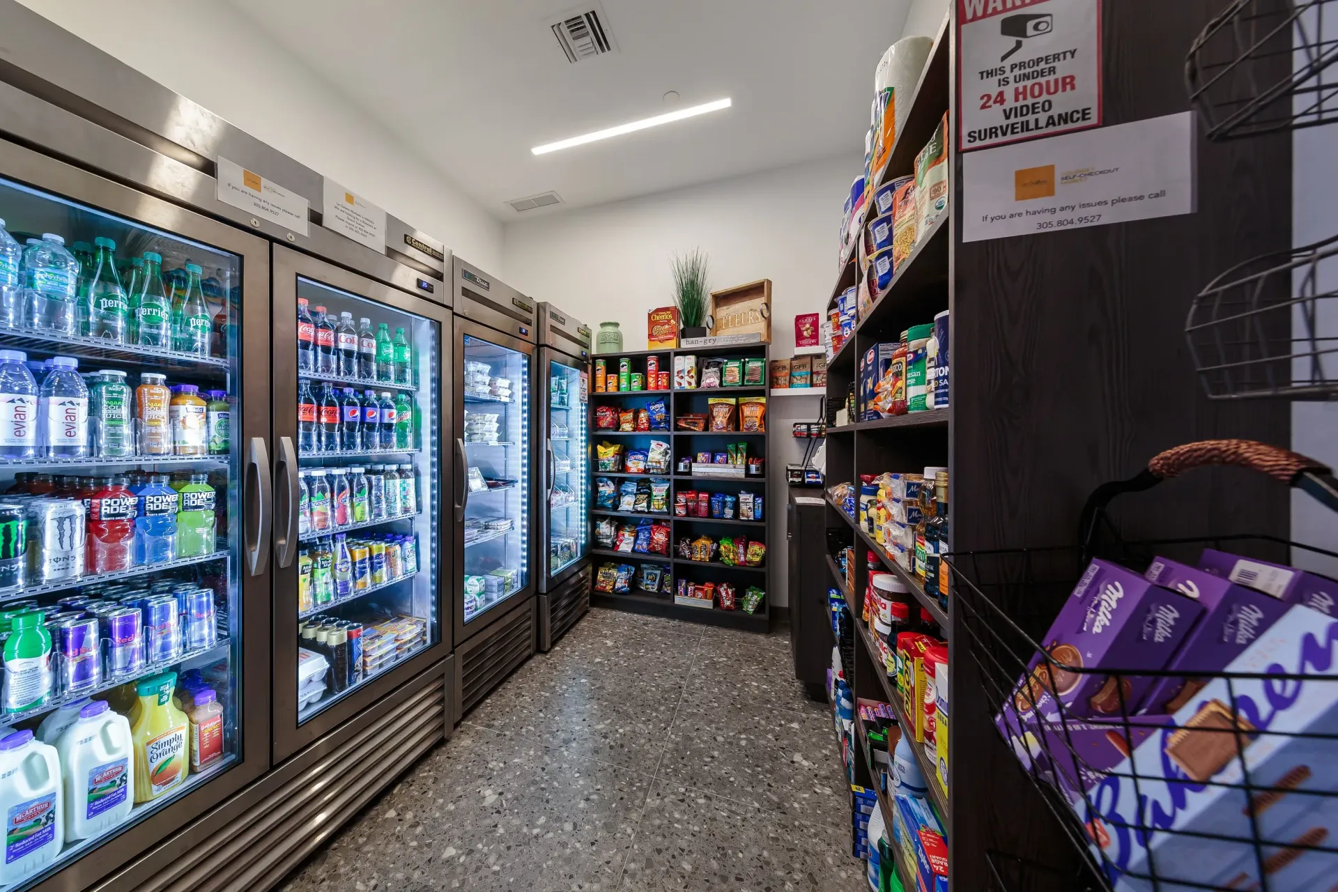 Interior of on-site convenience market with glass-door refrigerators and snack shelves.