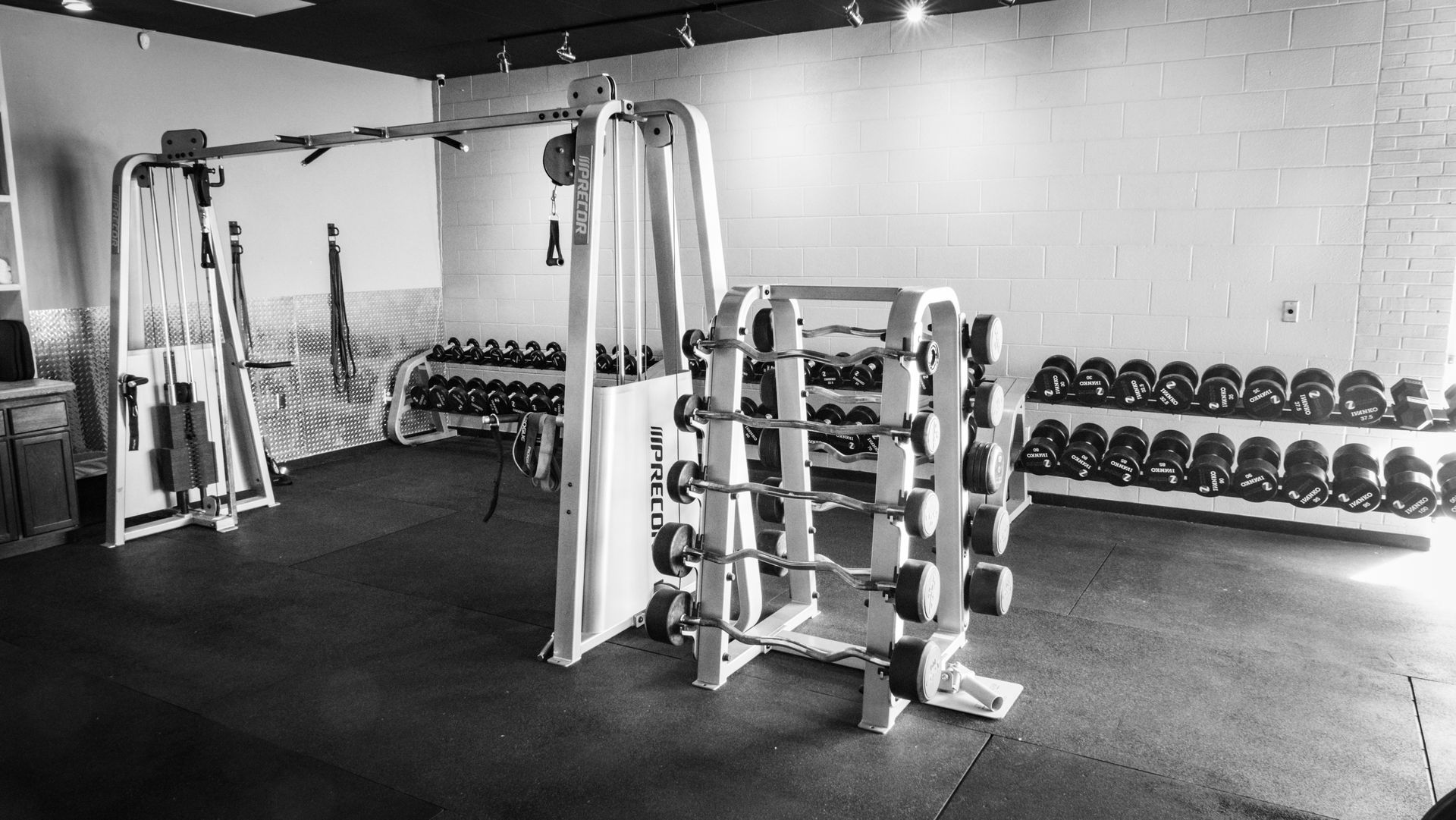 Strength training area with dumbbells and cable machines at Fitness @ KT Black, Amarillo TX