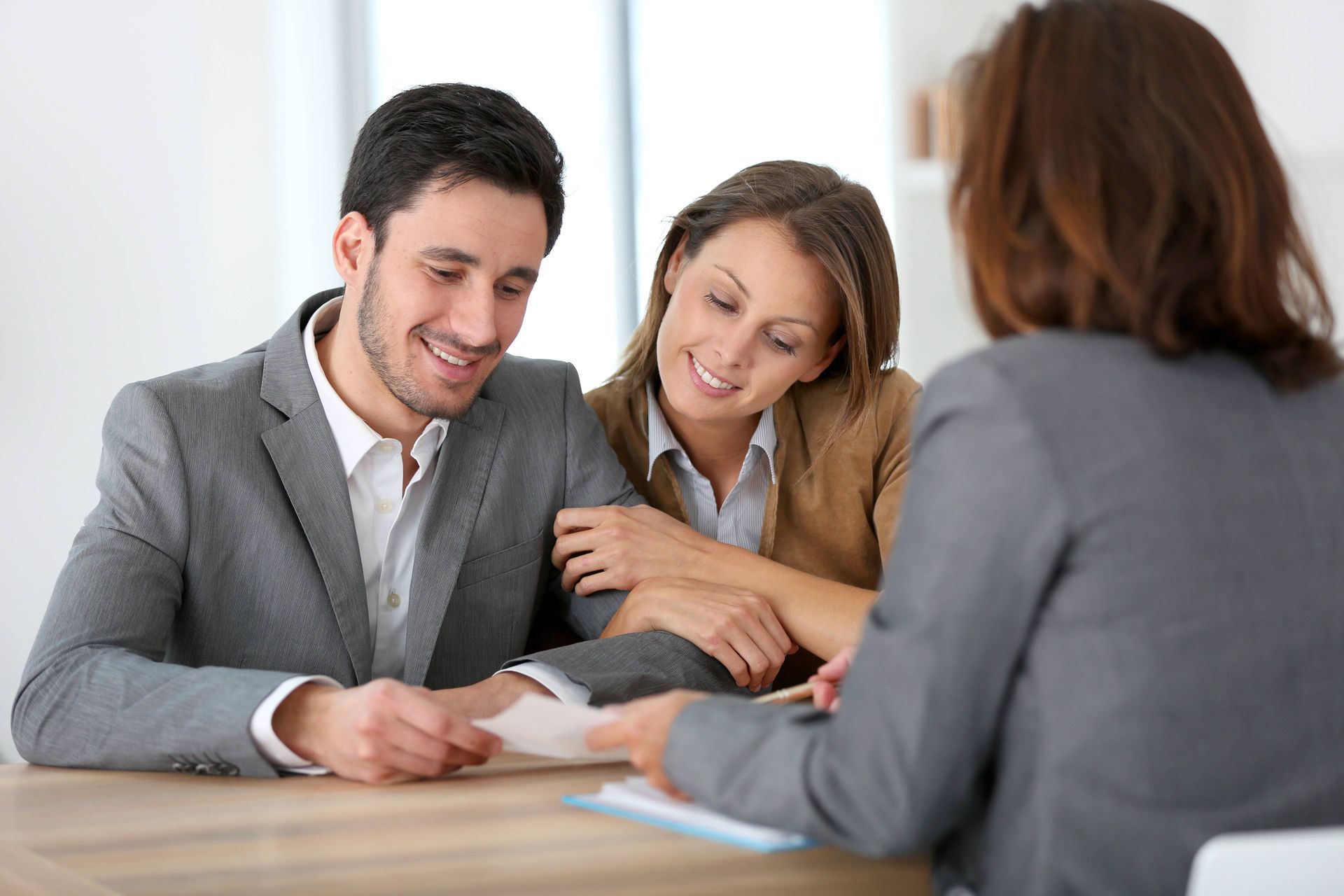 a man and a woman are sitting at a table talking to a woman