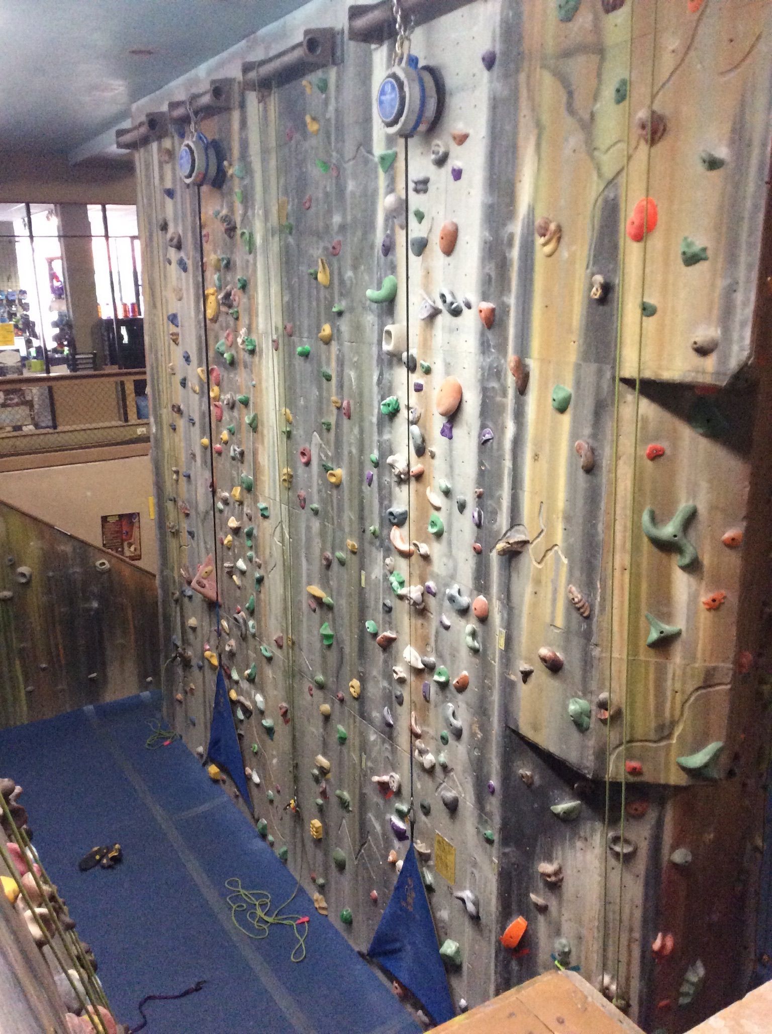 A climbing wall with a blue mat underneath it
