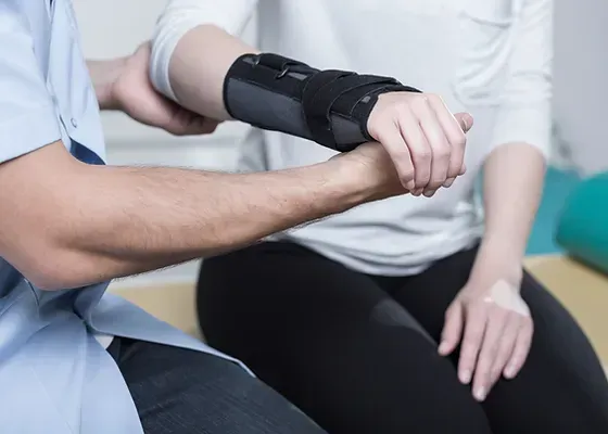 a man is putting a wrist brace on a woman 's wrist .