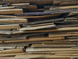 Stacked corrugated cardboard sheets in brown and tan tones