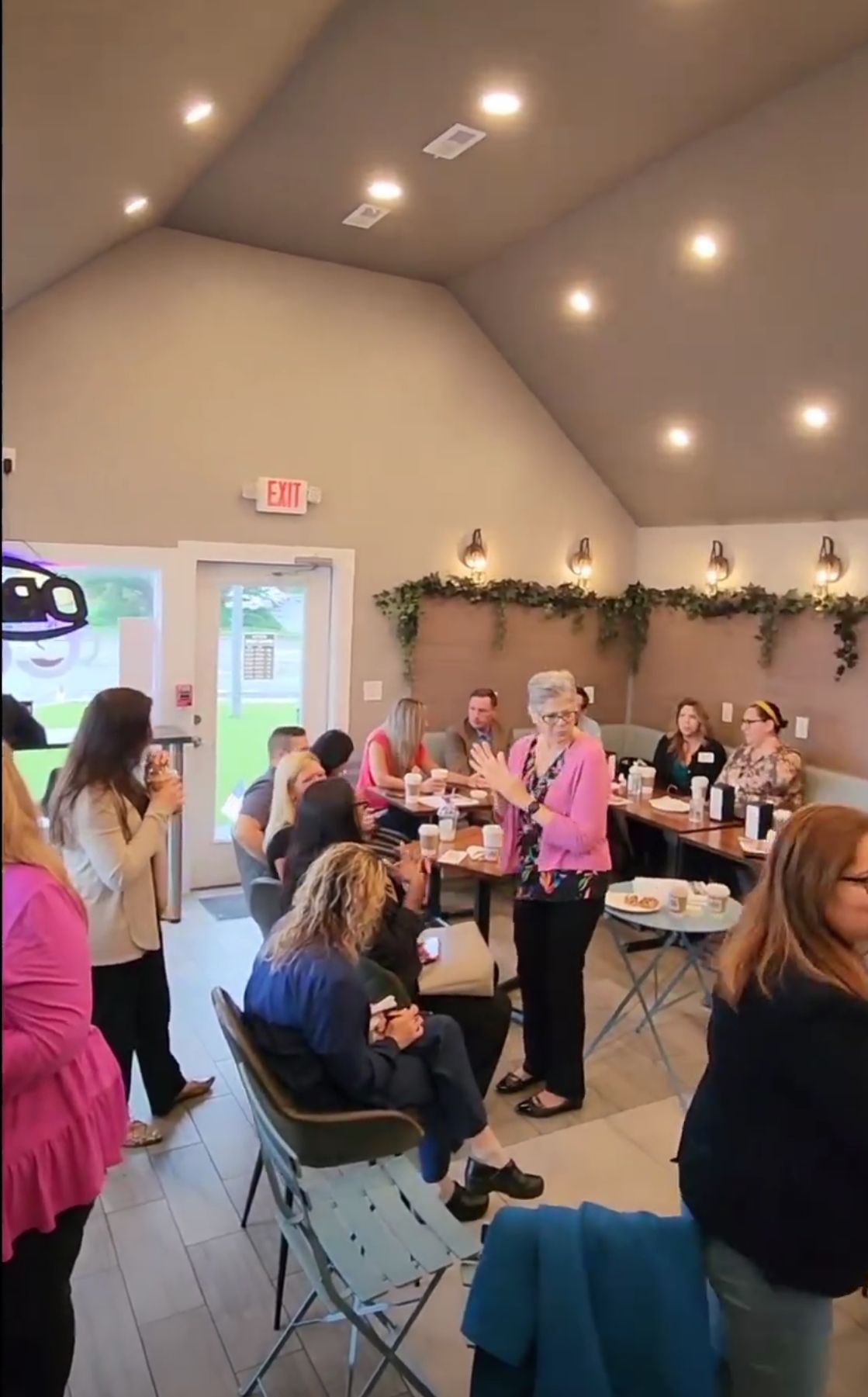 a group of people are sitting at tables in a room .