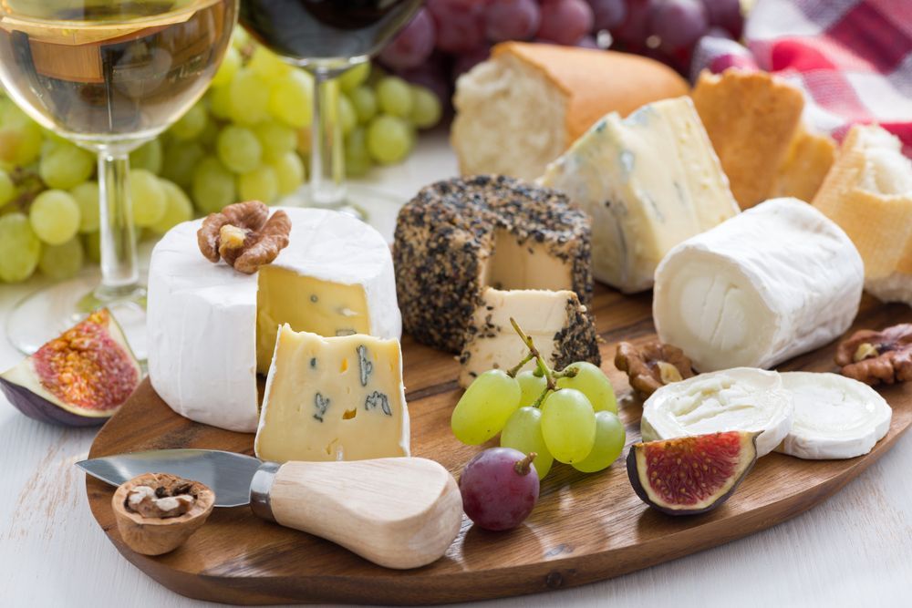 A wooden cutting board topped with a variety of cheeses, grapes, figs and nuts — Start Fresh Fruit Market in Bundaberg Central QLD