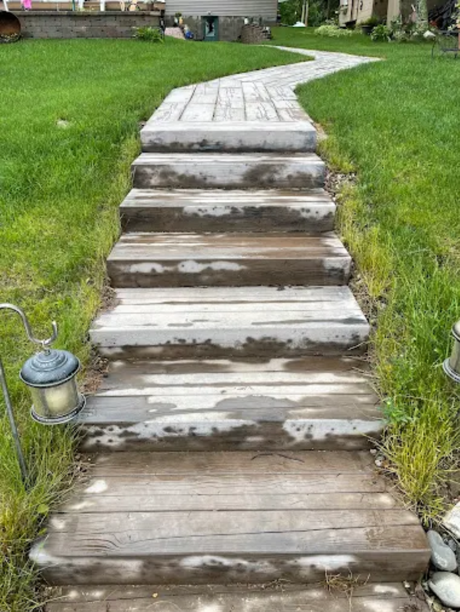 Weathered concrete steps leading up a grassy yard path, with a small lantern on the left.