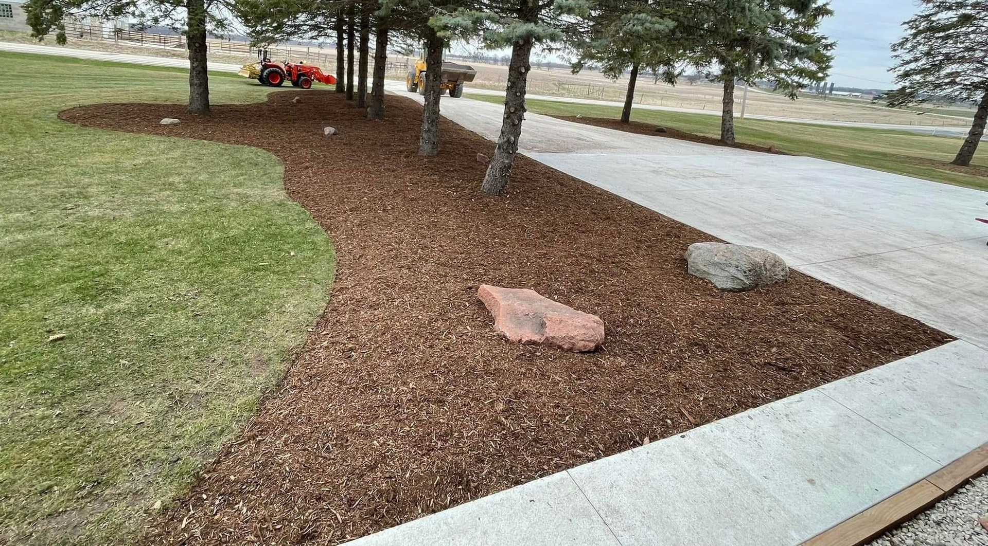 Curved stone garden border beside colorful flowers and green lawn