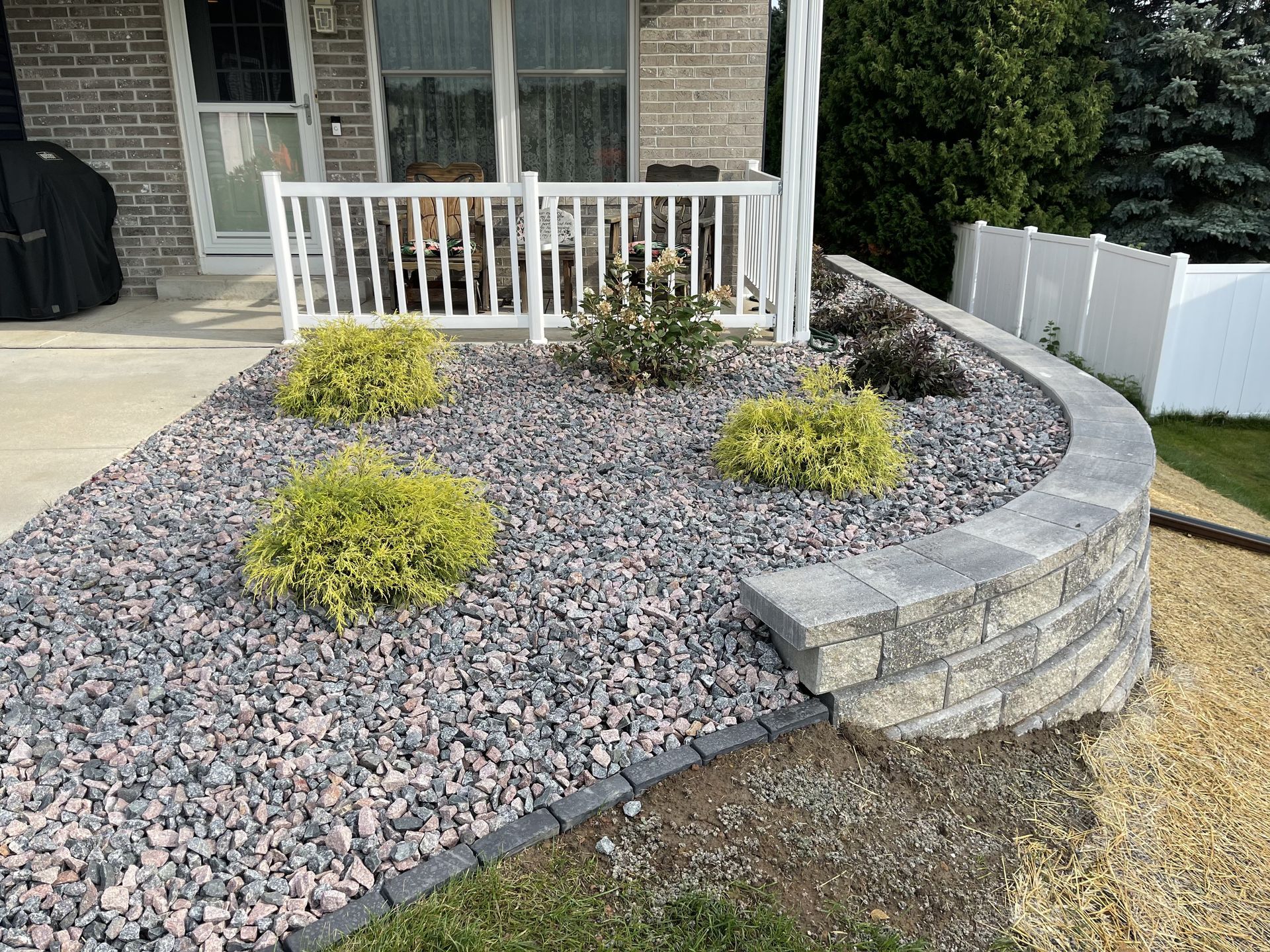 Curved stone walkway with gray gravel landscaping and beige home